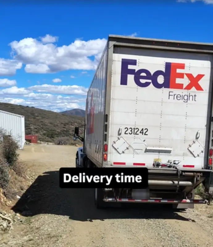FedEx Freight truck backing down a desert gravel road to deliver a pallet of playing cards