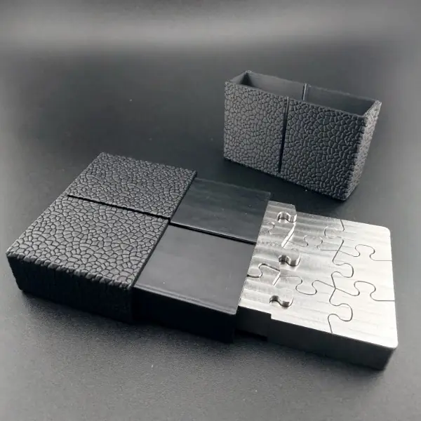 NEUTRINO assembled stainless steel puzzle block sliding into its textured black case