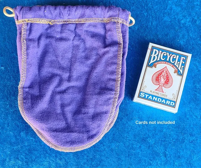 Back of the purple Sly Designs drawstring bag next to a Bicycle deck for size